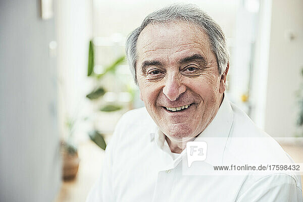 Smiling senior man with gray hair at home