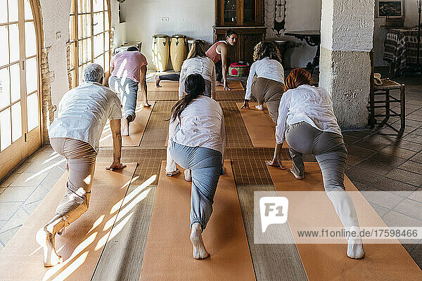 Freunde lernen Übung vom Lehrer im Yoga-Studio