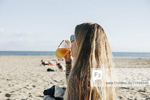 Hipster-Frau trinkt Saft am Strand  Gran Canaria  Kanarische Inseln