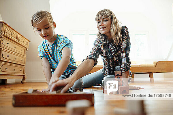 Mother and son playing toy blocks at home
