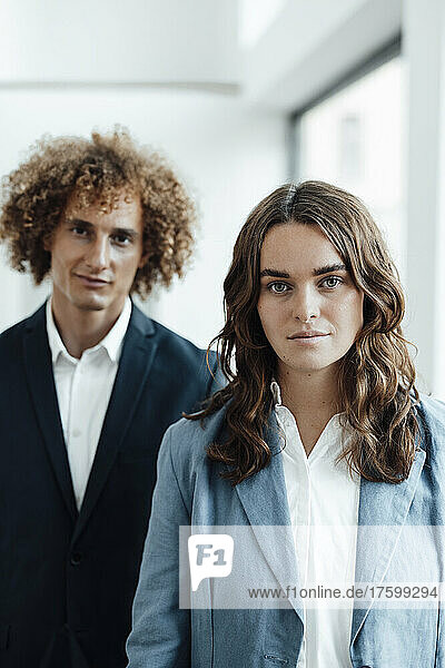 Young businesswoman standing with businessman at coworking office