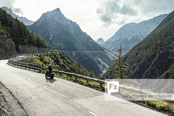 Biker riding motorcycle on road by Lechtal valley  Pfafflar  Tirol  Austria