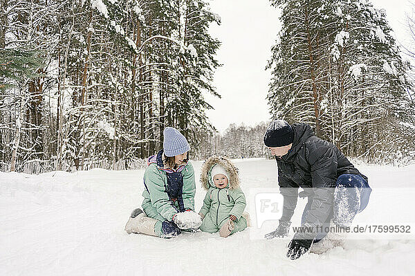 Happy family playing with snow in winter