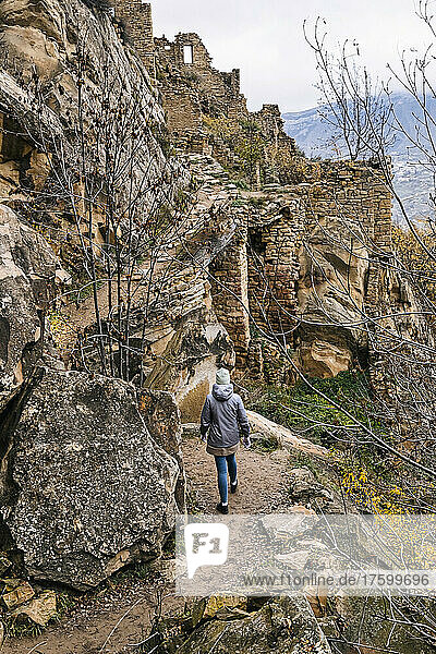 Russia  Dagestan  Gamsutl  Female tourist exploring old abandoned mountain village in North Caucasus