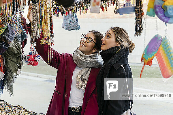 Young women enjoying shopping at street market