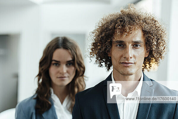 Curly haired businessman with businesswoman in office
