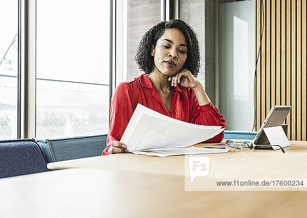Businesswoman examining documents at desk in office