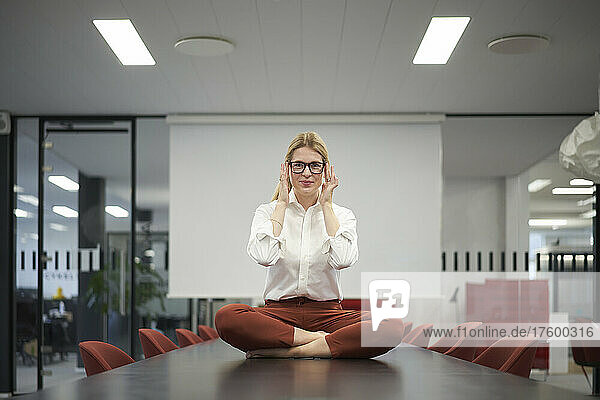 Businesswoman with eyeglasses sitting on conference table in meeting room
