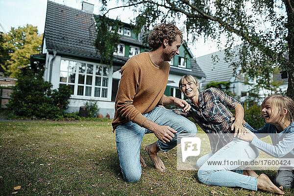 Cheerful parents playing with son in garden