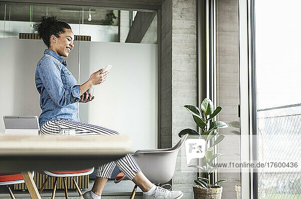 Businesswoman using smart phone at work place