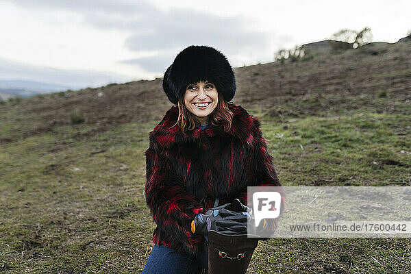 Smiling woman wearing fur hat at ranch