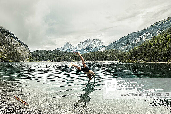 Tourist diving in Blindsee lake by Mieming Range  Tirol  Austria