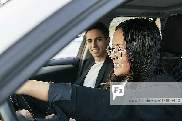 Businessman looking at businesswoman driving car