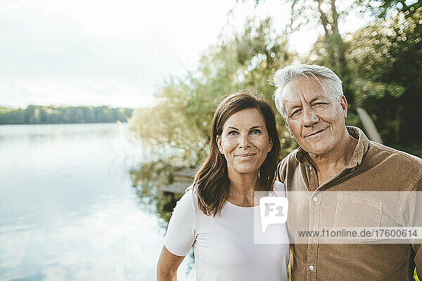 Lächelnder älterer Mann und Frau stehen am See