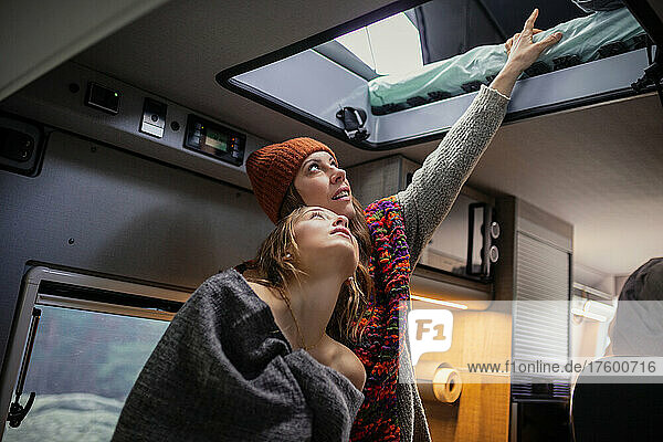 Friends looking at bed in motor home
