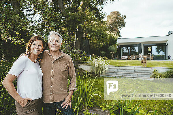 Smiling woman with brown hair standing by man at backyard