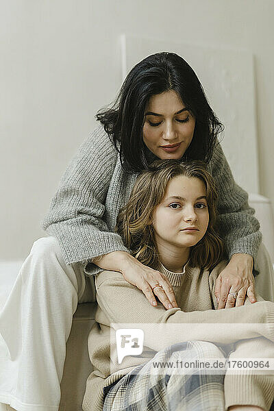 Mother sitting with daughter in living room