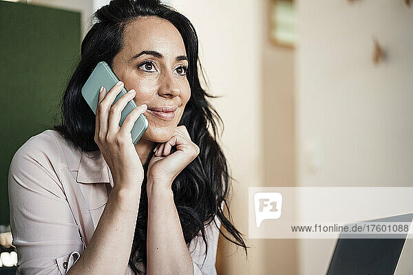 Businesswoman talking on smart phone in office