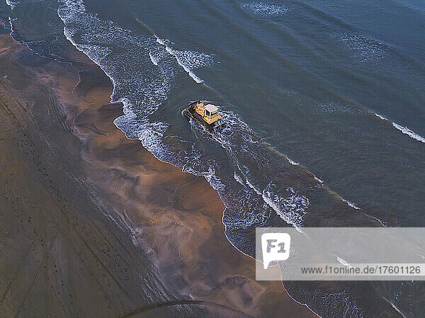 Russia  Dagestan  Derbent  Aerial view of bulldozer driving along sandy seashore