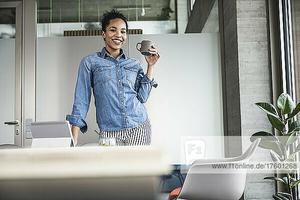 Smiling businesswoman with coffee cup in office