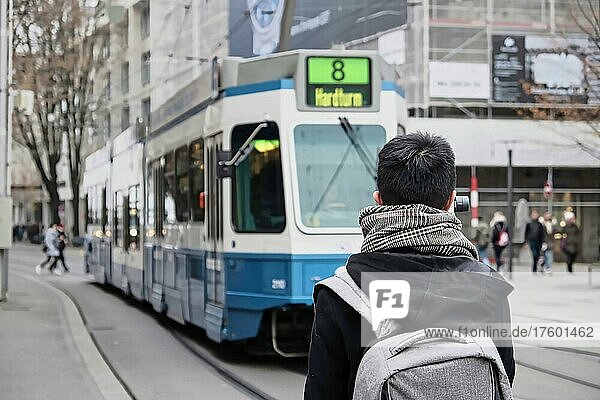 Mann vor einem blauen Tram in Zürich  Schweiz  Europa