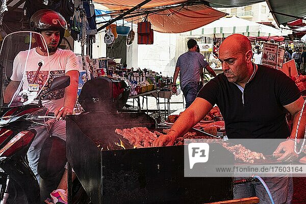 Skewers  barbecue at Ballaro market  customer on motorbike  cook  oldest street market in Palermo  Albergheria district  Palermo  Sicily  Italy  Europe