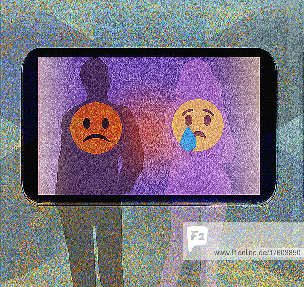 Paar mit traurigen Emoticons auf dem Telefondisplay