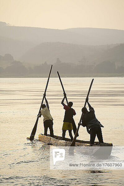 Young Congolese fisherman paddle their pirogue across the Zaire River.; Congo River  Democratic Republic of the Congo.