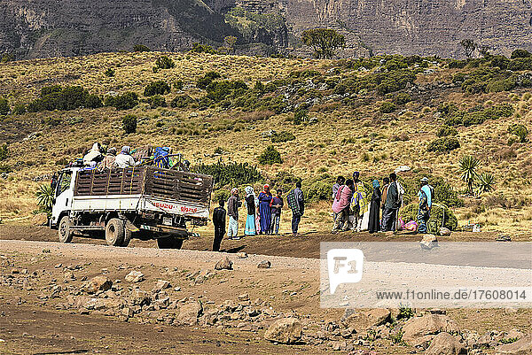 Menschen stehen auf dem Rücksitz eines Lastwagens und am Straßenrand in den Simien-Bergen im ländlichen Äthiopien  Semien-Nationalpark; Äthiopien