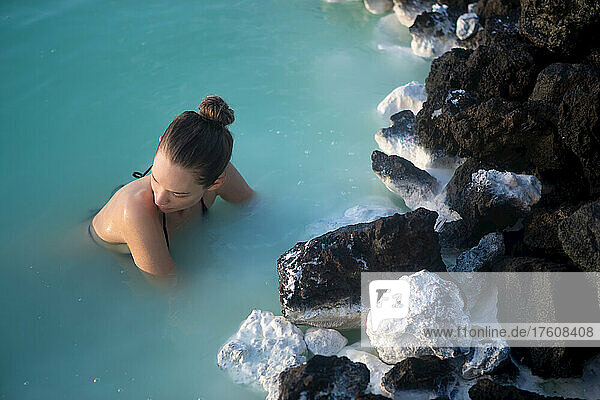 Eine Frau schwimmt in der blauen Lagune von Island.