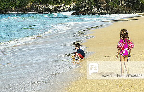 Im Sand spielende Kinder am D. T. Fleming Strand am Rande des Wassers; Kapalua  Maui  Hawaii  Vereinigte Staaten von Amerika