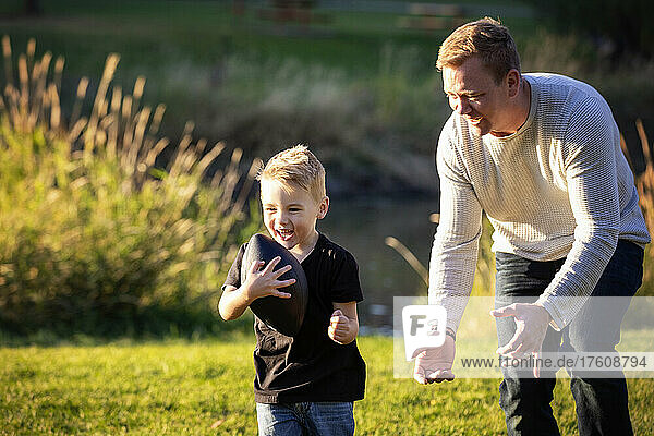 Vater spielt Fußball mit seinem kleinen Sohn in einem Park im Herbst; St. Albert  Alberta  Kanada
