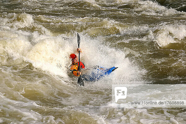 A whitewater kayaker blasts a big hole at Rock Island.; Rock Island  Tennessee.