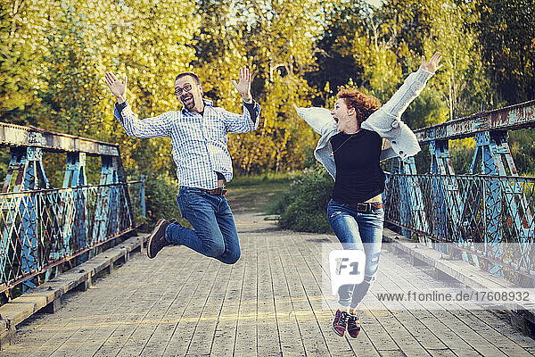 Älteres Ehepaar springt in einem Park in ausgelassener Feierlichkeit in die Luft; Edmonton  Alberta  Kanada