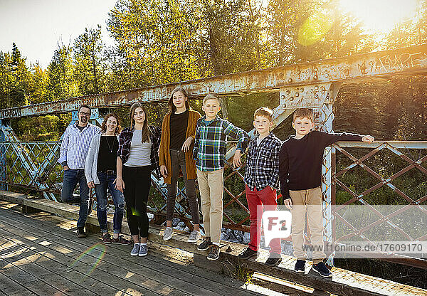 Siebenköpfige Familie auf einer Brücke für ein Familienporträt in einem Stadtpark im Herbst; Edmonton  Alberta  Kanada