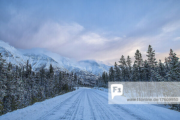 Sunrise over the snow-covered mountains of the Gray Ridge along the Annie Lake Road in early morning light in winter; Whitehorse  Yukon  Canada