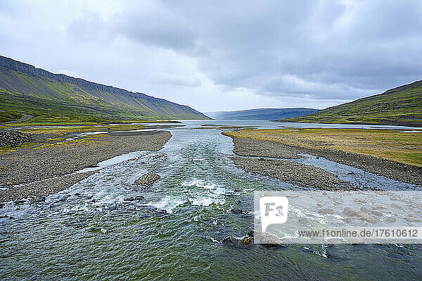 Fließender Fluss in der Fjordlandschaft des Vestfjardarvegur im Sommer; Westfjorde  Island