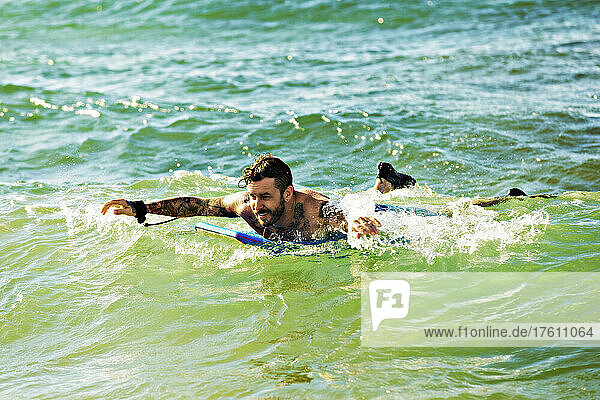Ein Mann paddelt im Wasser auf einem Bodyboard am D. T. Fleming Beach; Kapalua  Maui  Hawaii  Vereinigte Staaten von Amerika