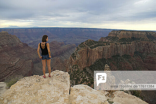 Eine junge Frau bewundert die Landschaft des Grand Canyon.