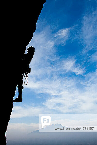 A climber ascends an overhang 500 feet off the ground.