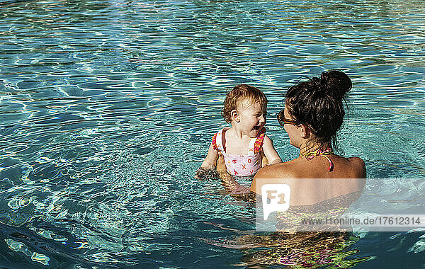 A mother swims with her baby daughter in the pool at a resort in Ka'anapali; Ka'anapali  Maui  Hawaii  United States of America