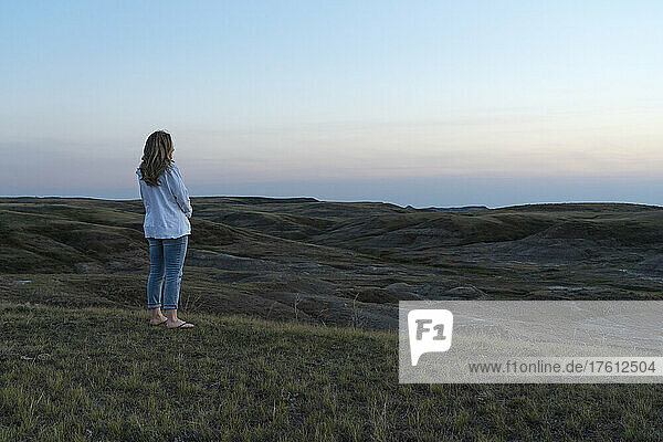 Frau betrachtet den Sonnenuntergang über den Prärien von Saskatchewan im Grasslands National Park; Saskatchewan  Kanada