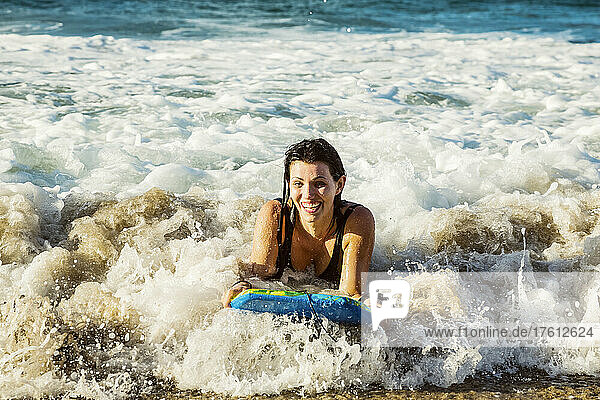 Nahaufnahme einer Frau  die auf einem Bodyboard eine Welle ins Ufer reitet  am D. T. Fleming Beach; Kapalua  Maui  Hawaii  Vereinigte Staaten von Amerika