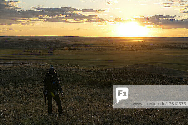 Woman viewing the sun setting over the prairies of Saskatchewan; Val Marie  Saskatchewan  Canada