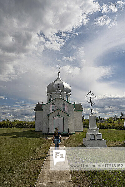 Frau  die auf die Türen der orthodoxen Kirche Saints Peter and Paul im ländlichen Saskatchewan zugeht; Krydor  Saskatchewan  Kanada