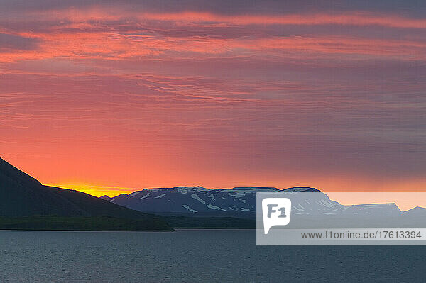 Mitternachtssonne (Sonnenuntergang um 12.15 Uhr) über dem Myvatn-See  mit einer Silhouette des Vulkans Vindbelgjarfjall; Island