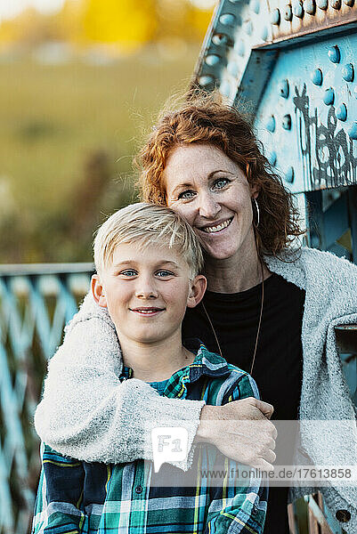 Outdoor portrait of a mother and son standing on a bridge at a park; Edmonton  Alberta  Canada