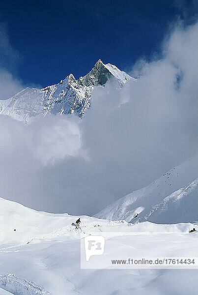 Mann beim Abstieg vom Annapurna-Basislager in die Wolken  Nepal; ANNAPURNA  NEPAL.