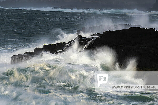 Unscharfe Bewegung von Wellen  die gegen die Felsen an der Küste Islands schlagen; Atlantik  Island