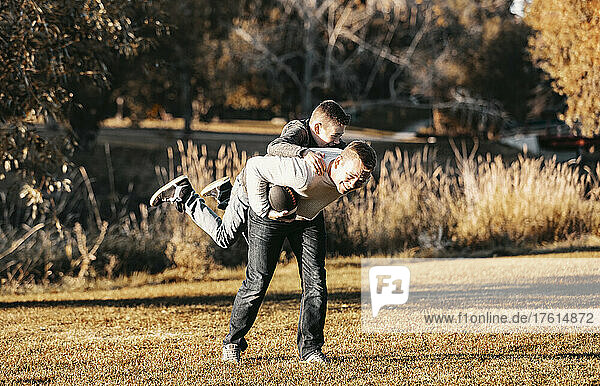 Father playing football with his son in a park in autumn; St. Albert  Alberta  Canada